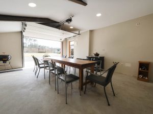 Interior del garaje acondicionado de Casa Bieiteiros con una mesa grande de comedor, ideal para reuniones a la sombra o días de lluvia en Valdoviño