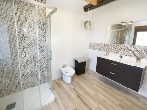 Amplio cuarto de baño en la planta alta de Casa Bieiteiros con mueble de doble cajón, espejo iluminado y ducha espaciosa en Valdoviño