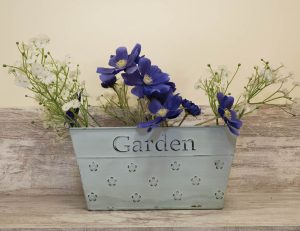 Primer plano de detalle decorativo con flores y cartel Garden en el salón de Casa Bieiteiros, Valdoviño