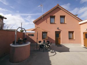 Vista frontal de Casa Bieiteiros con un antiguo pozo de piedra decorativo en el jardín, resaltando el estilo rural de Valdoviño
