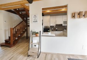 Vista del interior de Casa Bieiteiros con escalera de madera y cocina a la vista, un alojamiento acogedor en Valdoviño